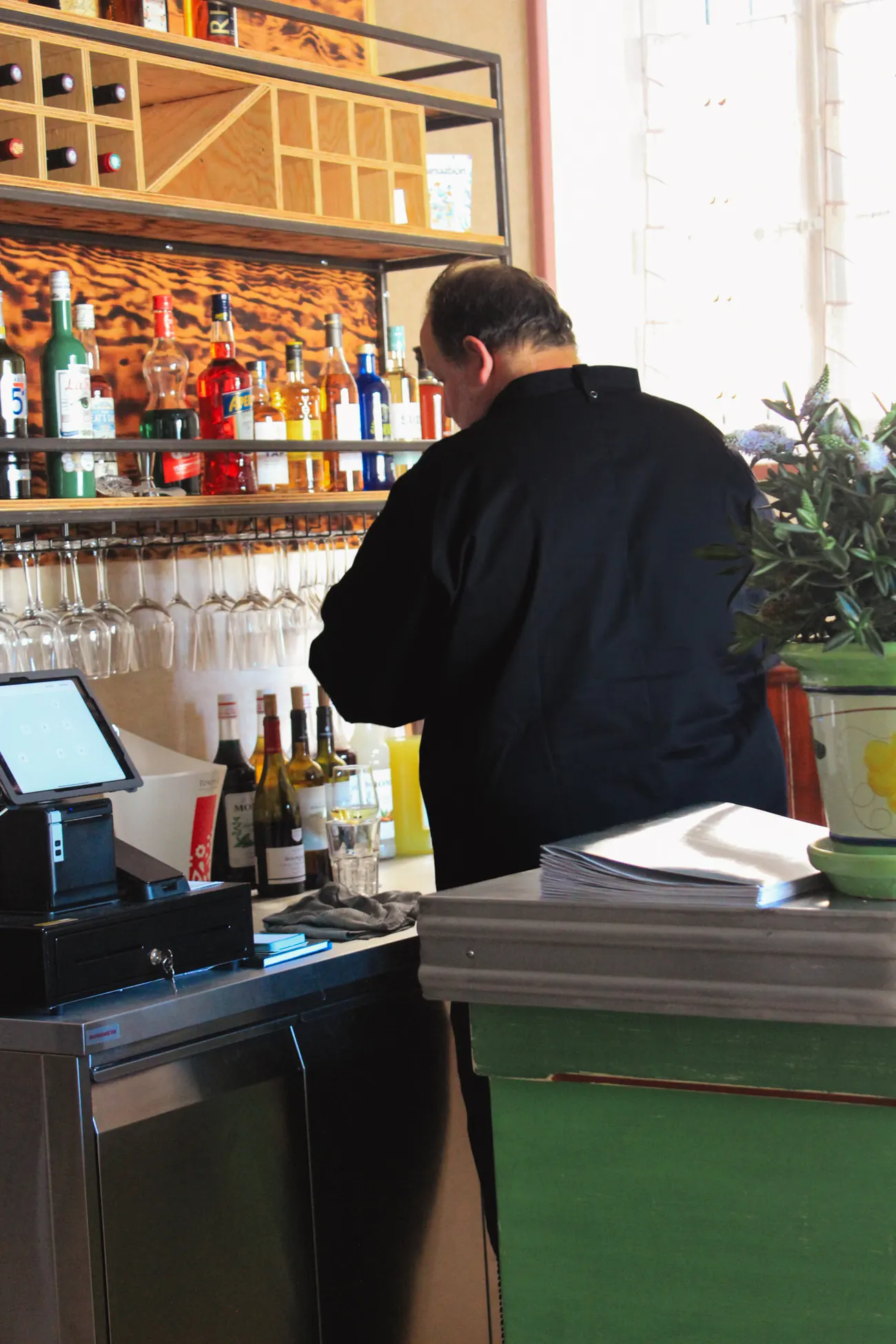 Le chef Stéphane Petit de dos au bar La Fée Verte